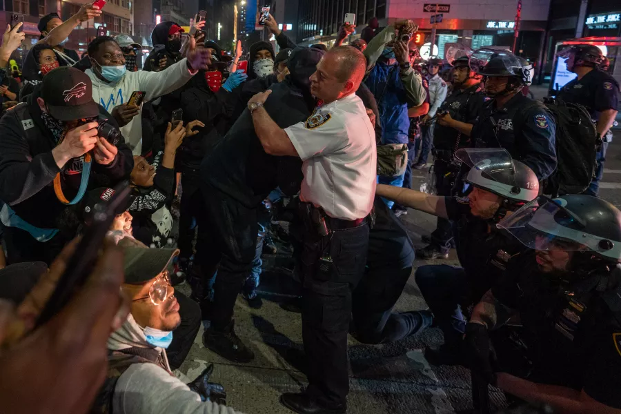 A policeman and protestor hug