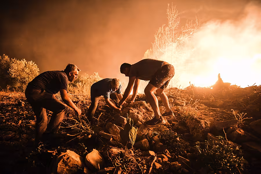 Villagers attempt to bring a fire in Kirli village, in Antalya province, under control 