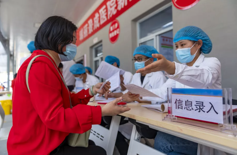 A woman registers for a Covid-19 vaccination in Ruili
