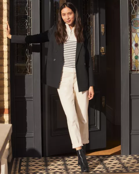 woman wearing stripey top, white jeans and blazer