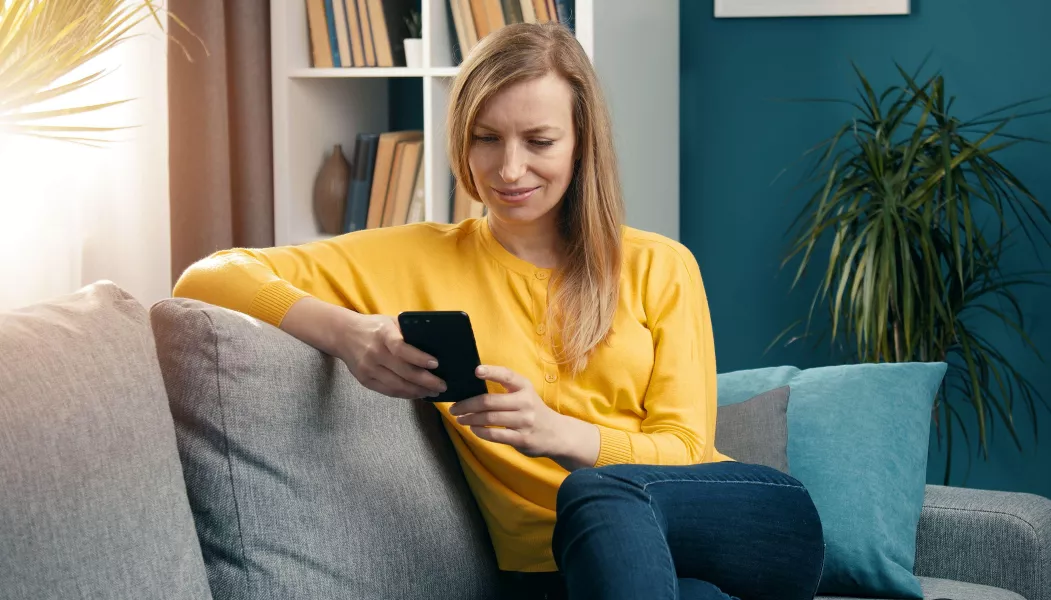 Cheerful woman browsing cellphone