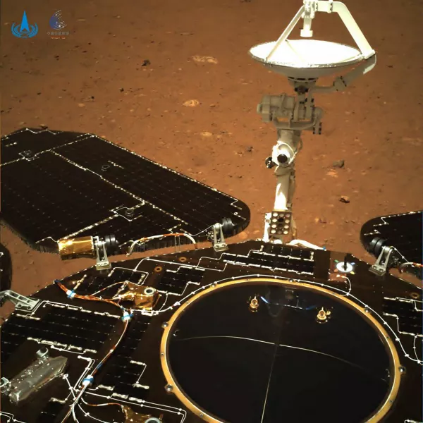The rover's solar panels and antenna are deployed as the rover sits on its lander on the surface of Mars