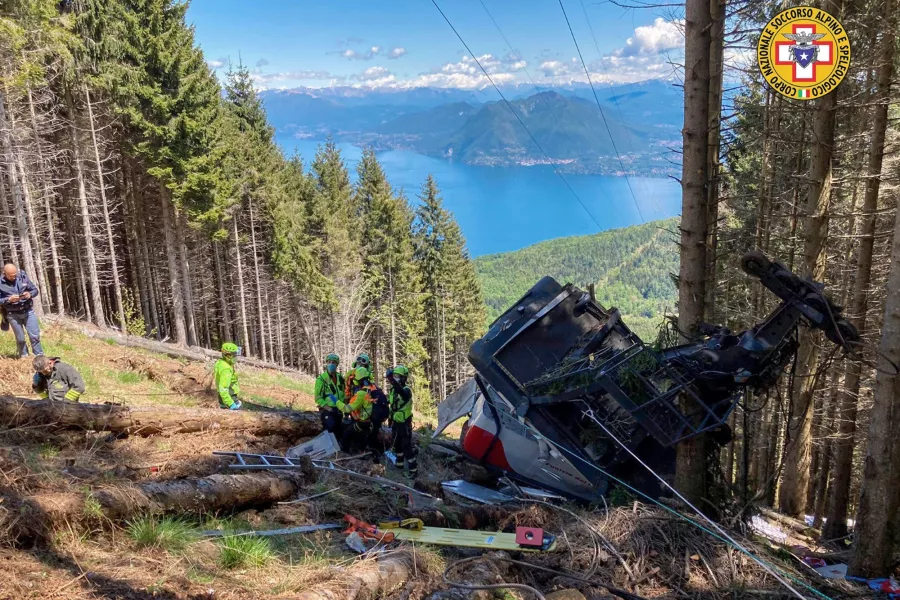 Rescuers work by the wreckage of a cable car after it collapsed near the summit of the Stresa-Mottarone line in the Piedmont region, northern Italy
