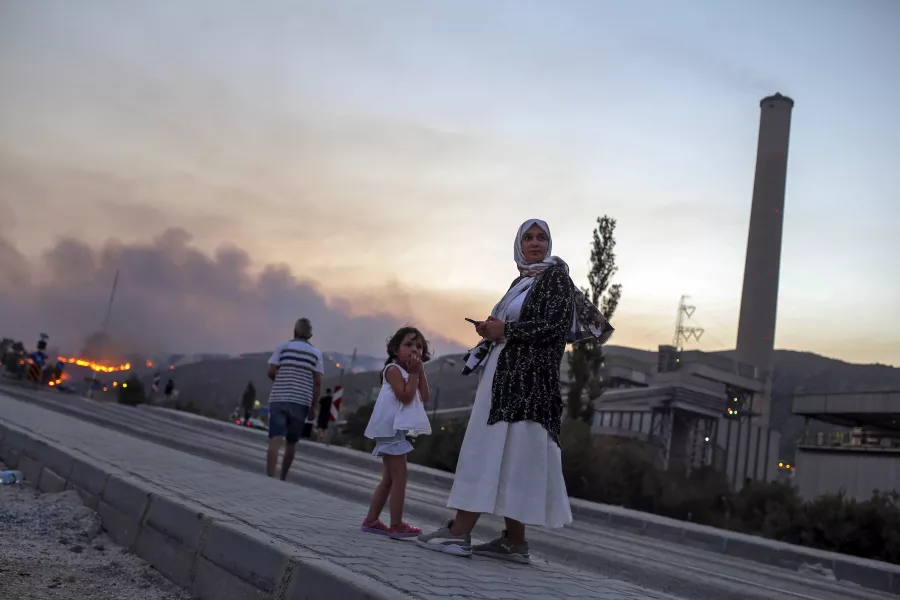 People stand in front of Kemerkoy thermal power plant