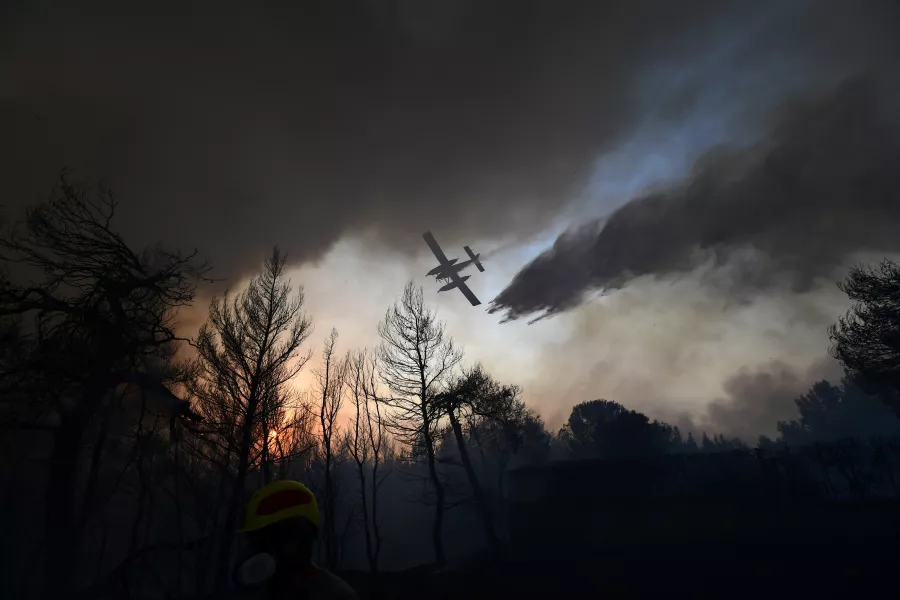 A plane drops water on a wildfire