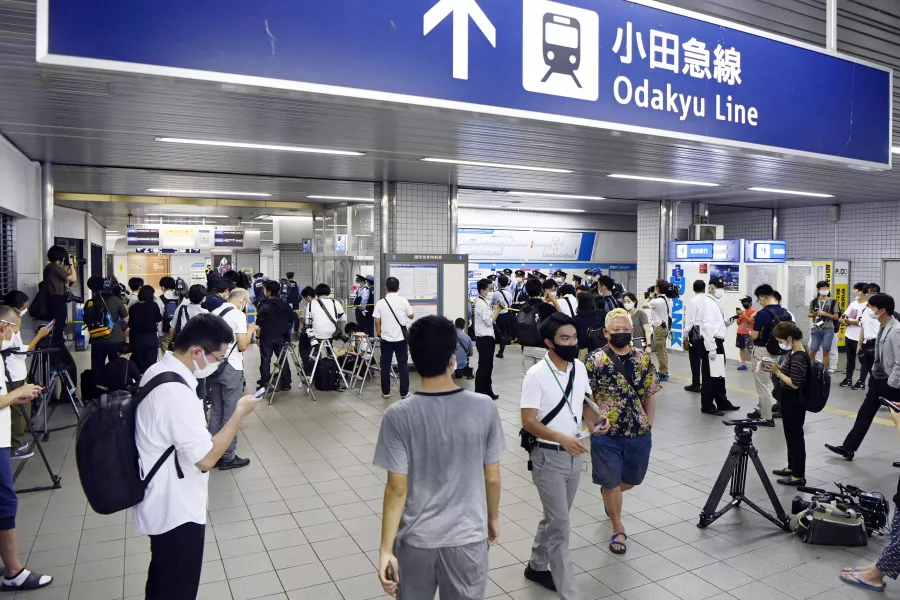 Police and media gather at Soshigaya Okura Station after a stabbing on a commuter train (Kyodo/AP)