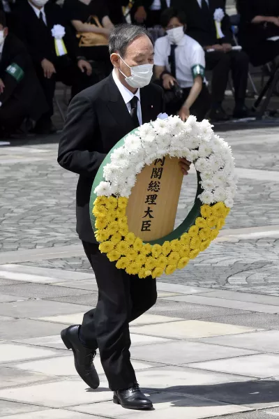 Japan's Prime Minister Yoshihide Suga offers a wreath during the ceremony