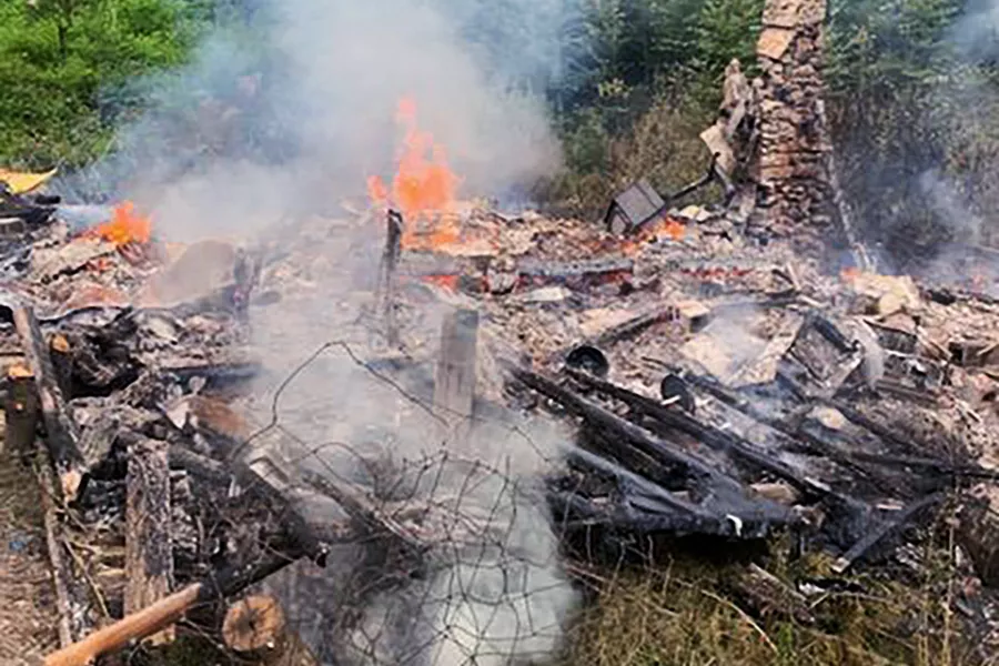 Smoke rises from the burnt remains of a cabin in Canterbury, New Hampshire, inhabited by 81-year-old David Lidstone