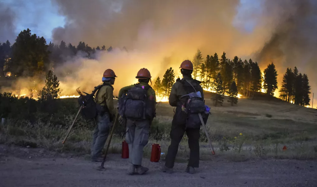 Firefighters watch a hillside burn on the Northern Cheyenne Indian Reservation 