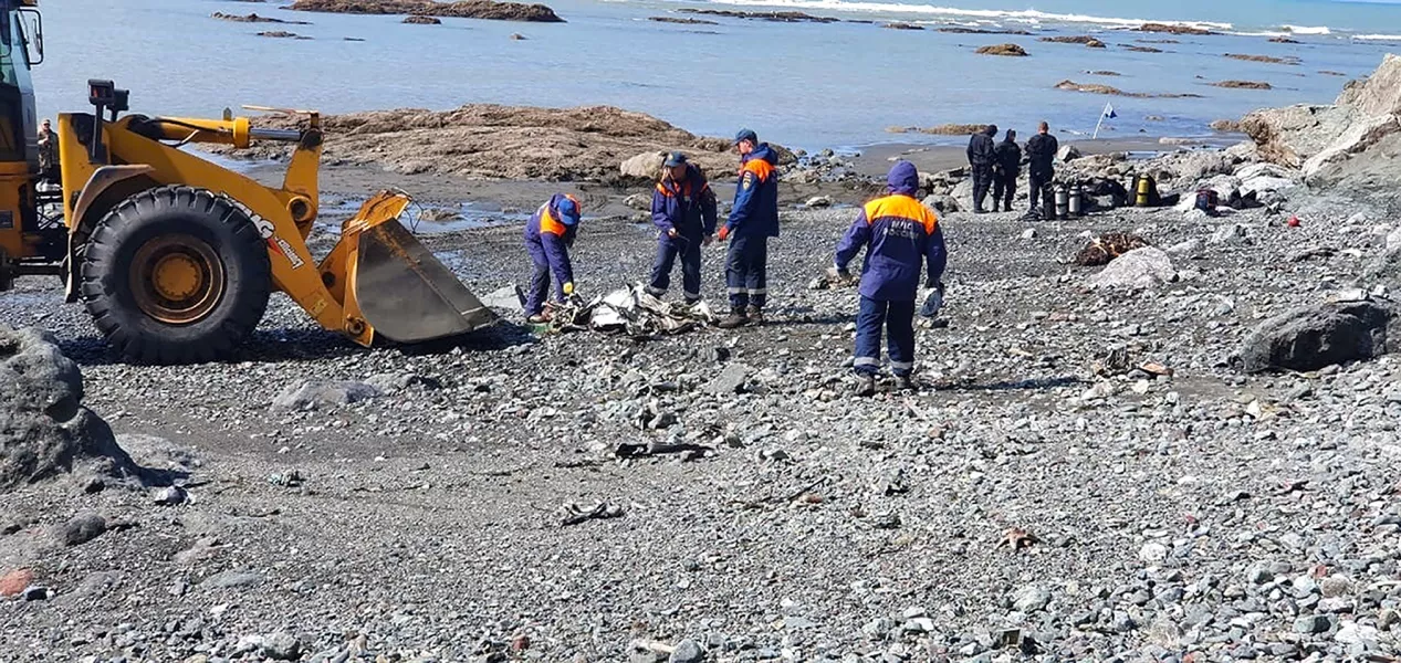 Emergency personnel work near the site where a helicopter carrying tourists crashed at Kurile Lake (Russian emergency ministry press service/AP)