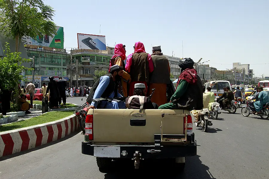 Taliban fighters sit on the back of a vehicle in the city of Herat, west of Kabul, Afghanistan 