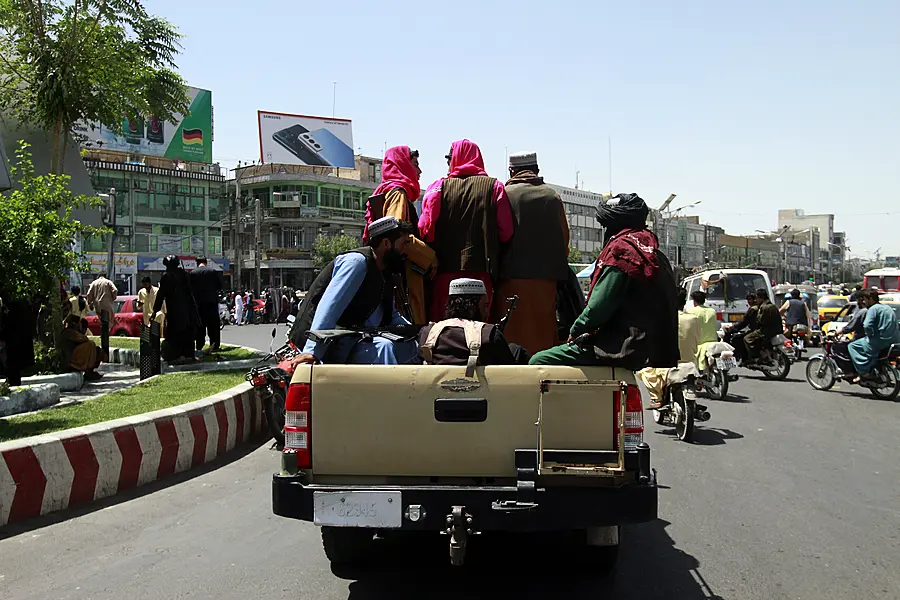 Taliban fighters sit on the back of a vehicle in the city of Herat, west of Kabul, Afghanistan 