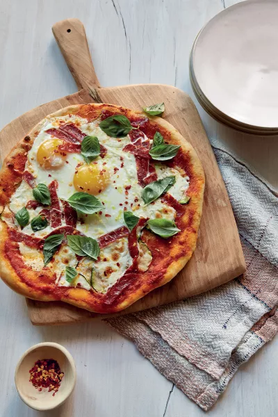 Breakfast for dinner pizza with eggs, courgette and spicy salami