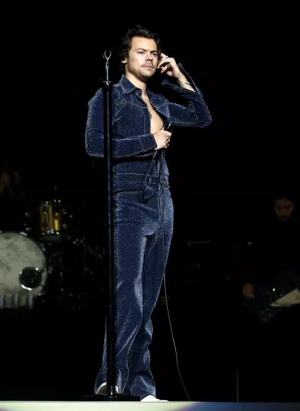 Harry Styles performing in a blue glittery jumpsuit in 2019 