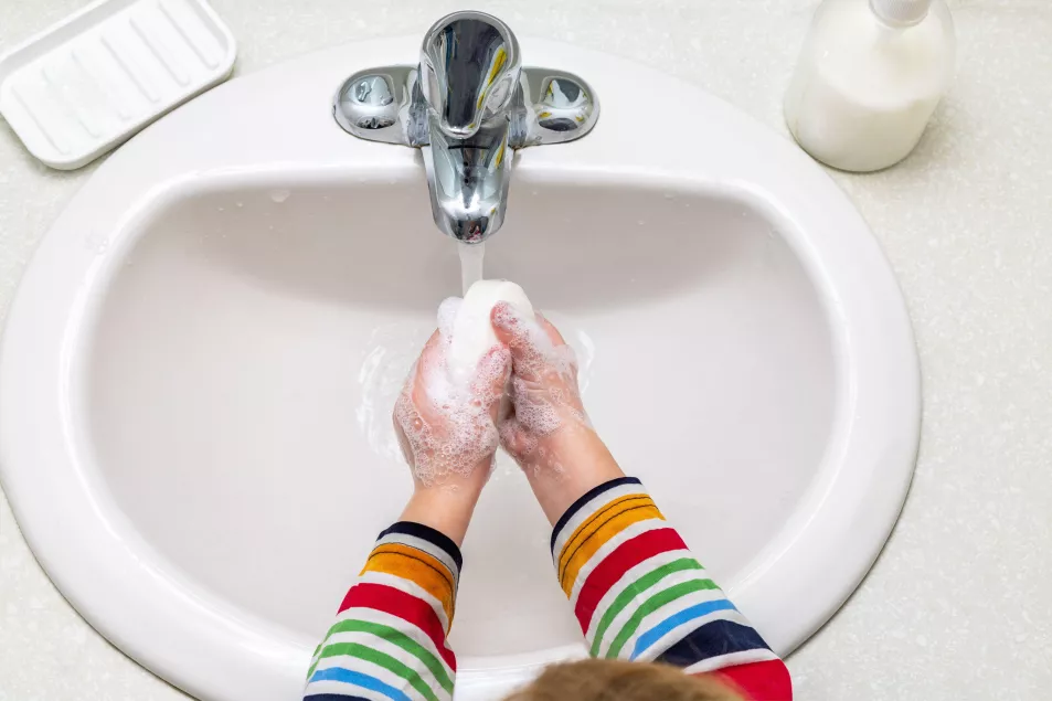 child washing hands with soap