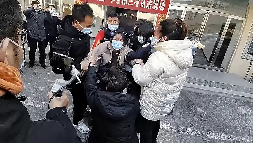 In this image taken from video, Li Jingwei, with back to camera, is reunited with his mother in Lankao in central China's Henan Province 