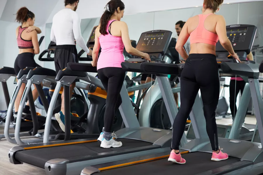 People Using Equipment In Busy Gym