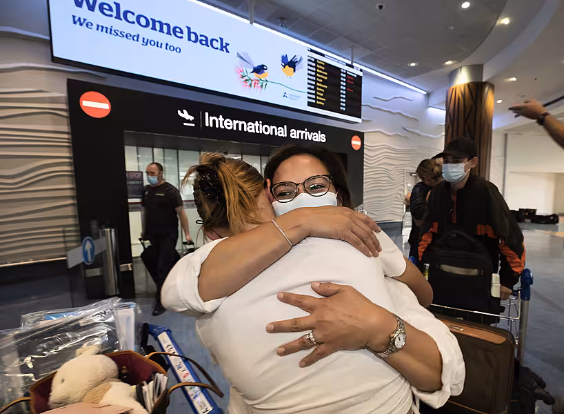 Two people hug at an airport