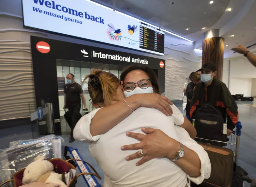 Two people hug at an airport