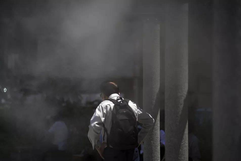 A person cools off at a cooling mist spot in Tokyo