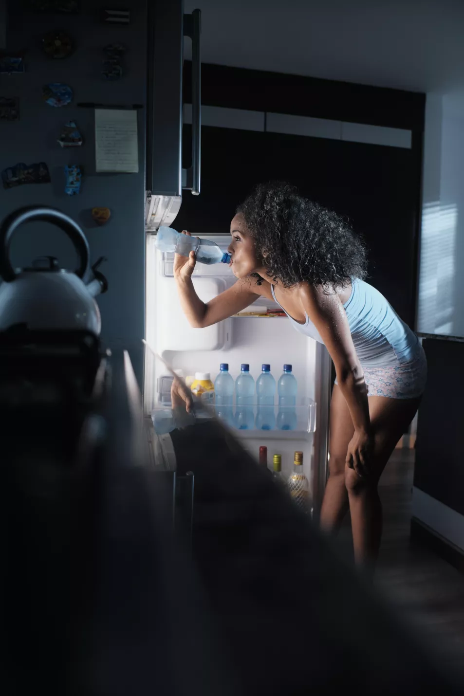 woman drinking cold water from the fridge