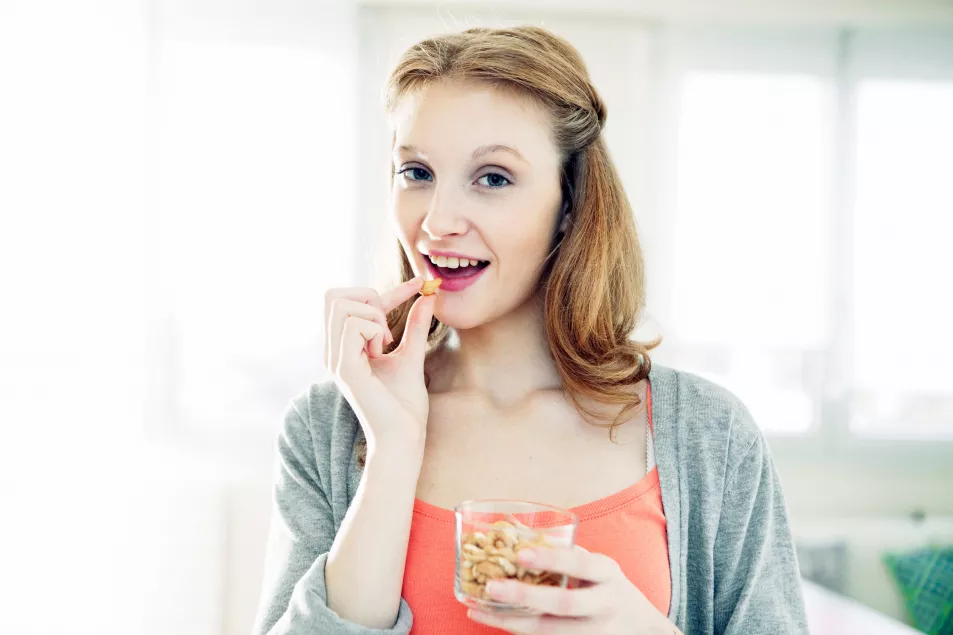 Woman snacking on a bowl of nuts