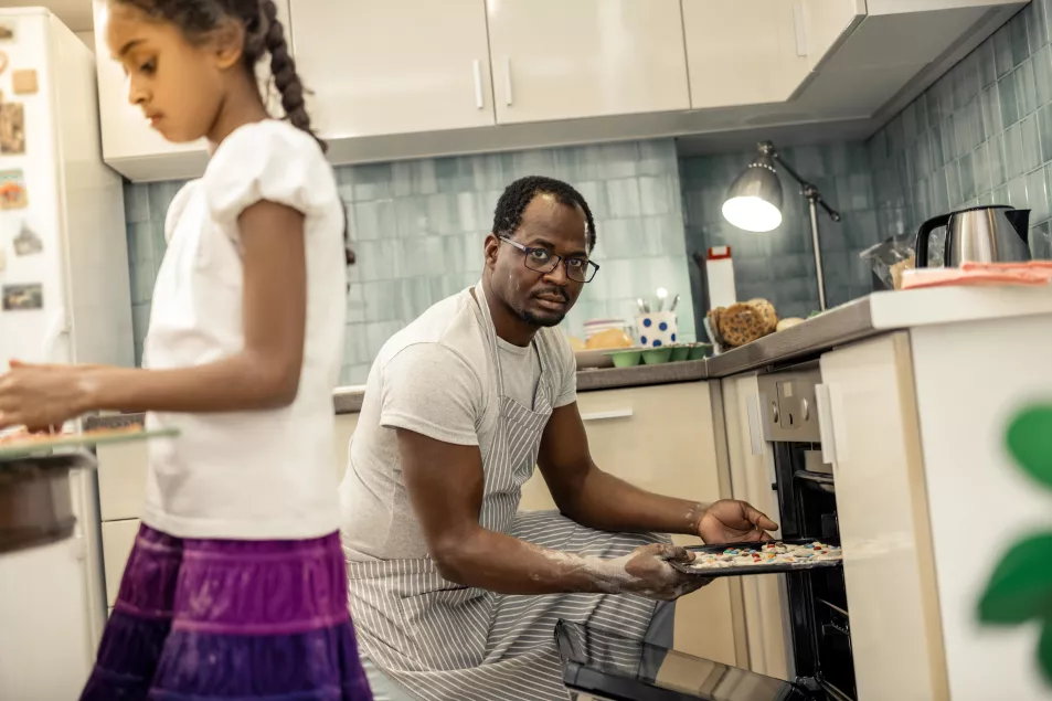 Man putting cookies in oven