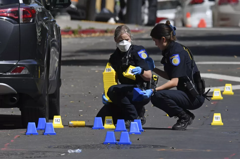 Sacramento Police crime scene investigators place evidence markers on 10th street at the scene of a mass shooting in Sacramento, Calif.