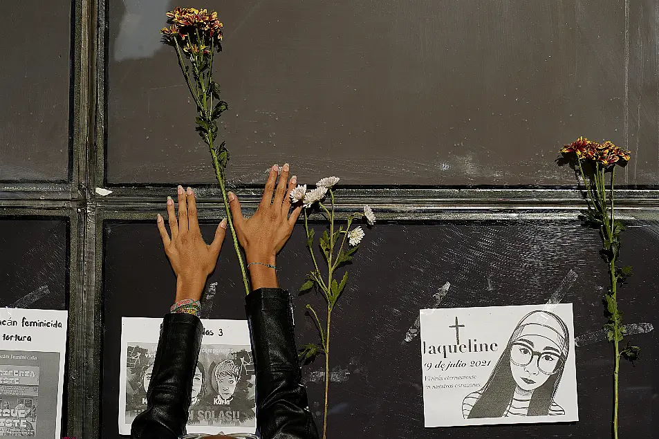 A woman places a stem of flowers on the facade of the Attorney General's office during a protest against the disappearance of Debanhi Escobar and other women who have gone missing, in Mexico City