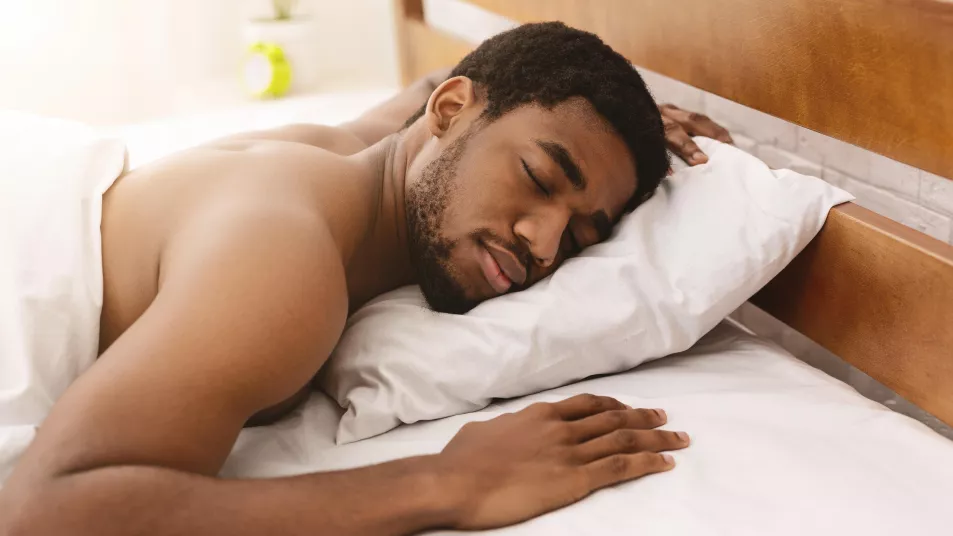 Man sleeping in bed with no clothes on