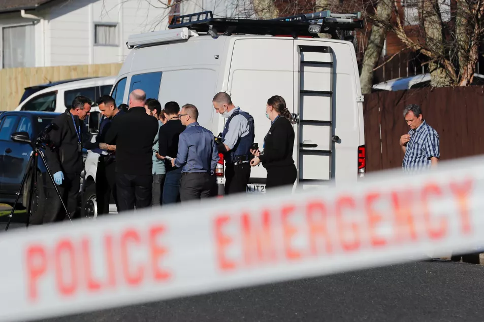 New Zealand police investigators work at a scene in Auckland after bodies were discovered in suitcases 