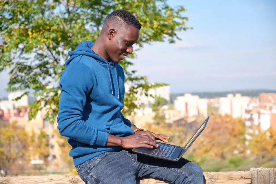 man working outside on laptop