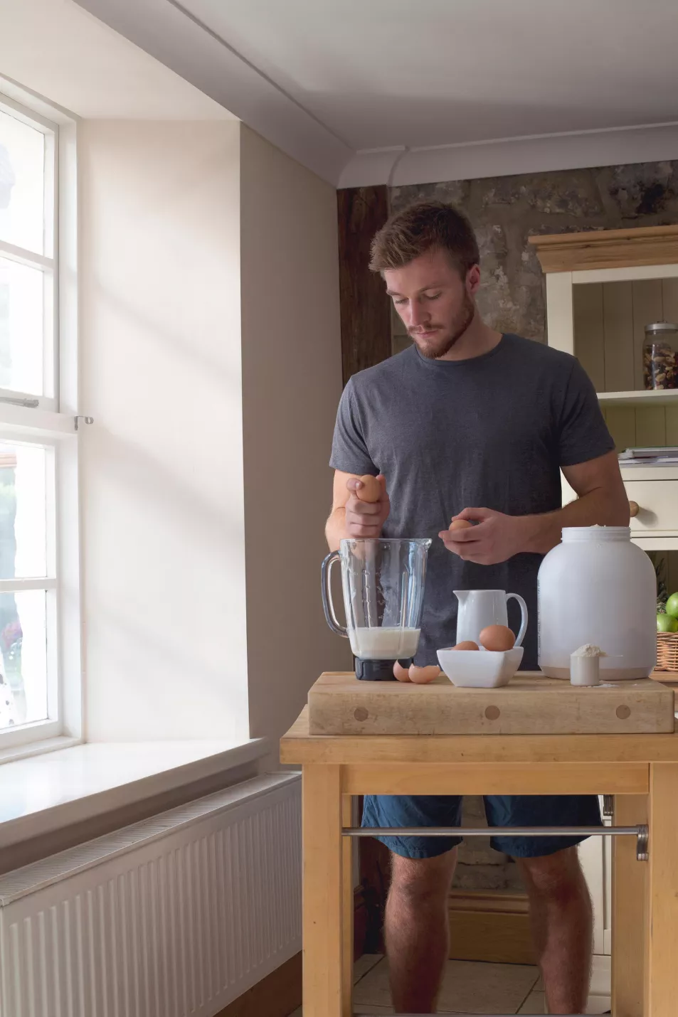 man making a protein shake at home