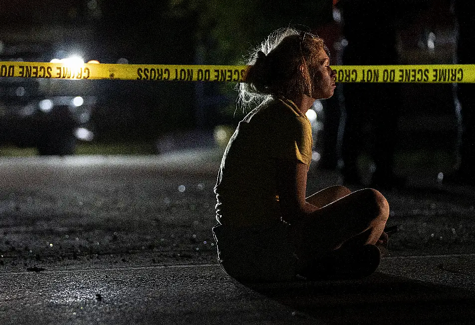 A woman watches the search, which ended when the bodies of a man and his three young children were found in a submerged car