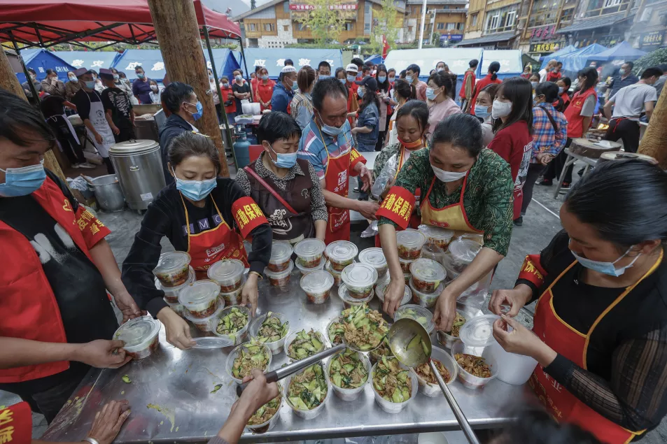 Volunteers prepare foods for survivors in Moxi Town