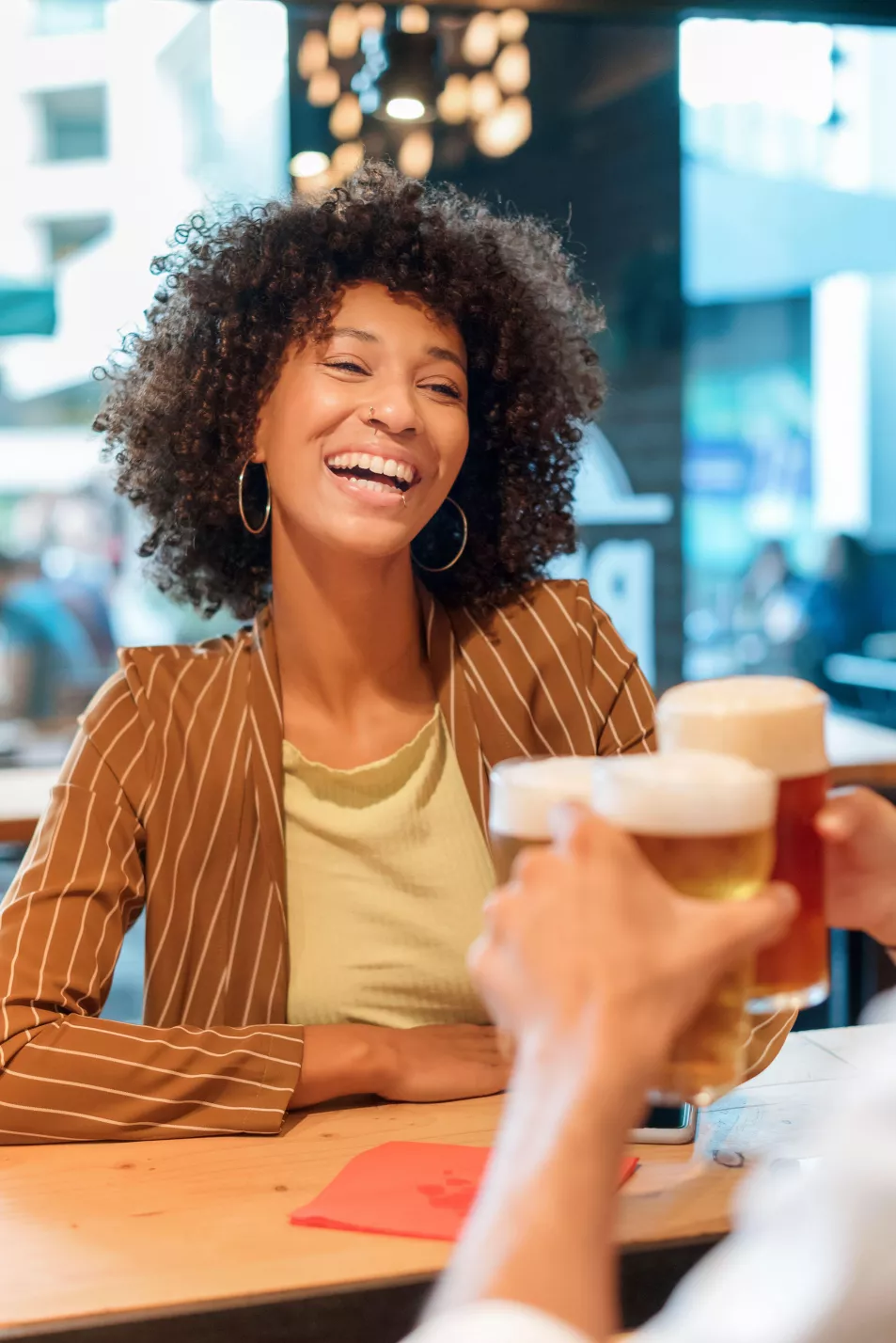 Woman toasting friends with beer
