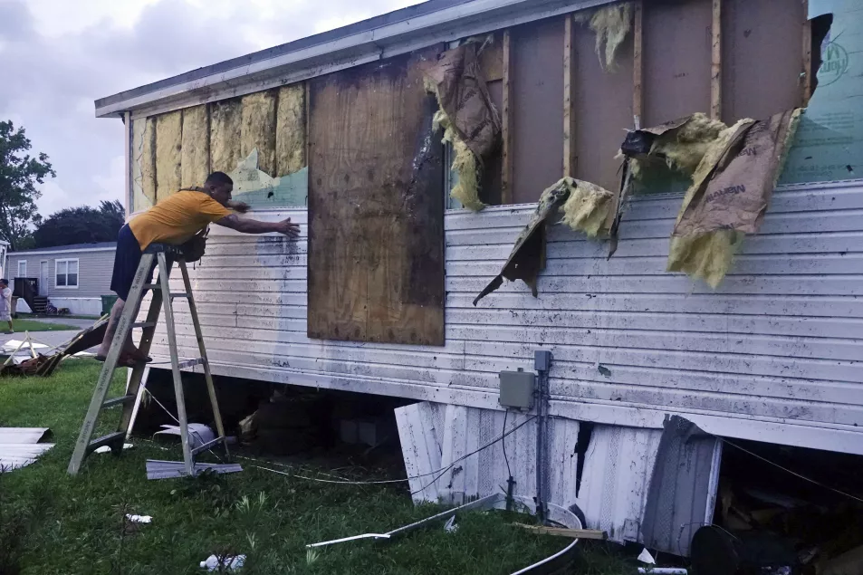 Ivan Mendoza begins to repair damage at his mobile home in Davie, Florida