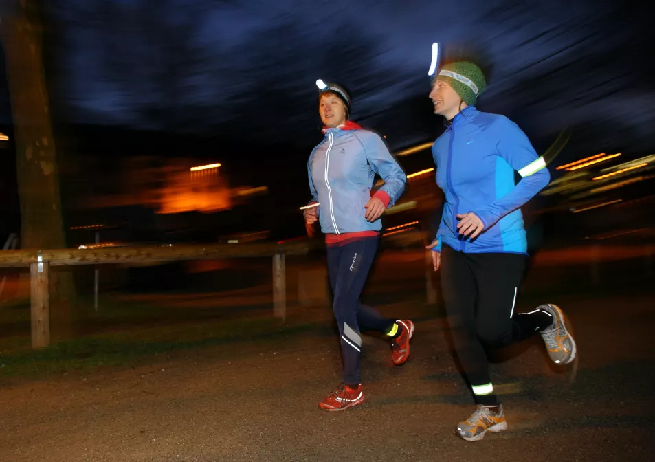 Women out running in the dark with headlamps on
