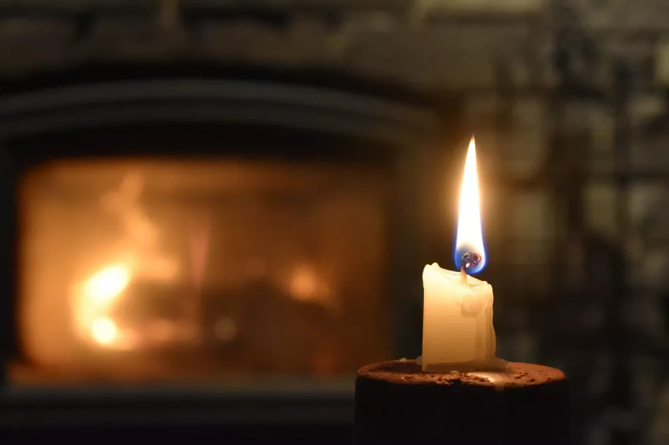 A candle burned low in front of fireplace