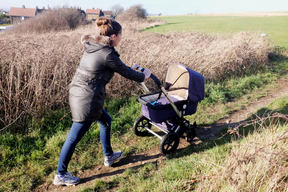 mother taking her baby for a walk in the countryside with a pram