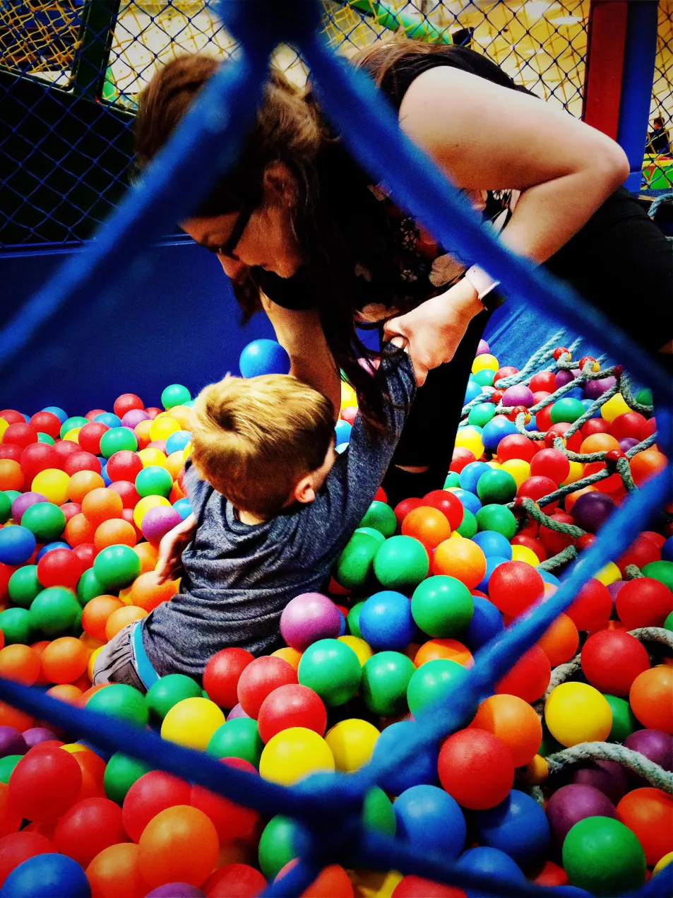 mum and son playing in ball pool