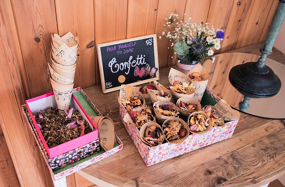 rose petal dried confetti at a wedding on a table for guests