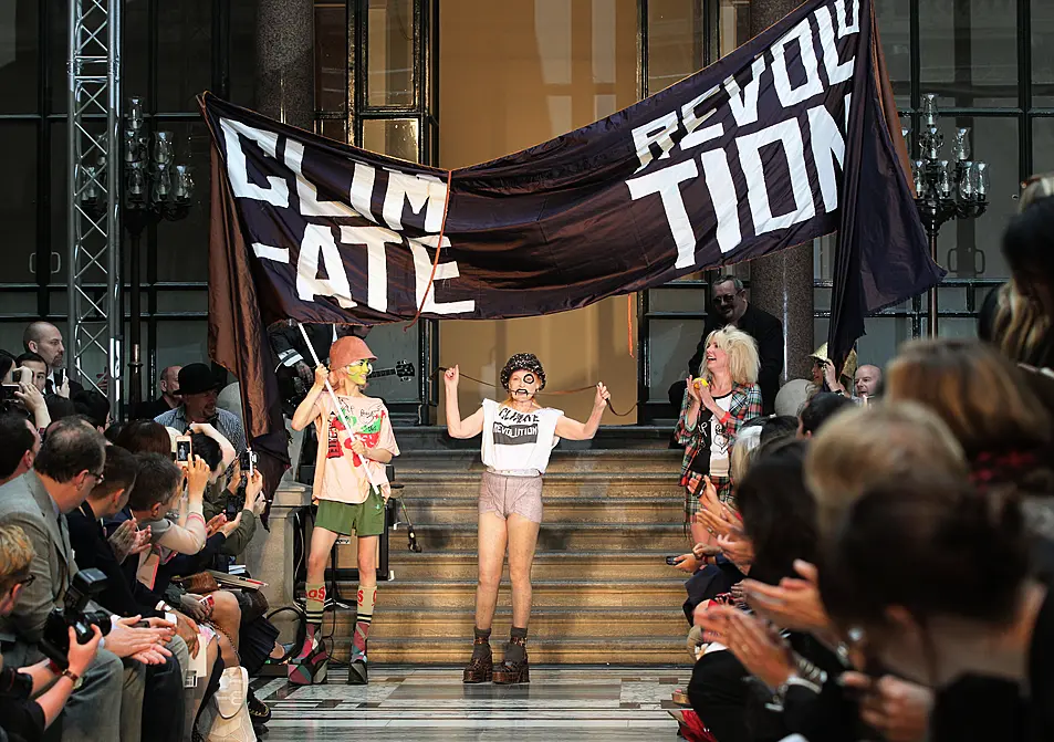 Vivienne Westwood on the runway in 2012 in a T-shirt saying 'climate revolution