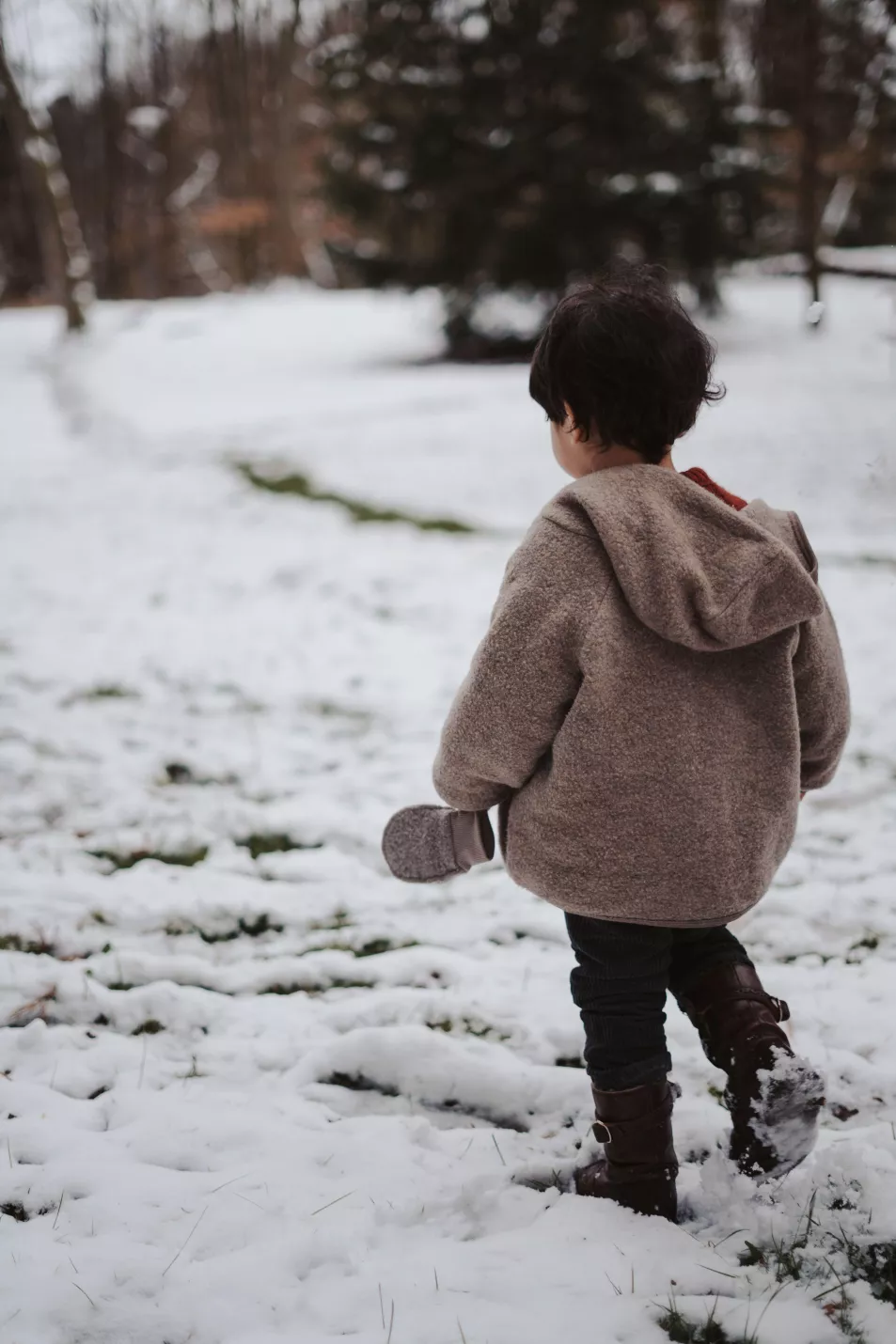 little boy running outside on a snowy cold winter day
