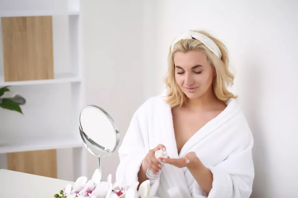 Beautiful woman face with moisturising cream. Skin care background.