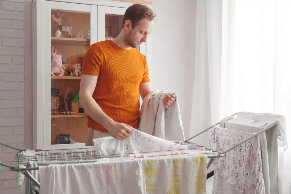 Man hanging laundry indoors