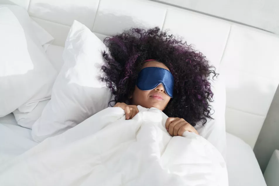 Woman in bed wearing a sleep mask