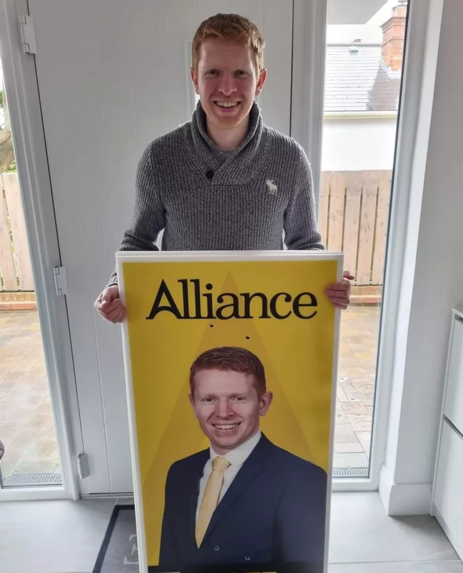 Alliance Party candidate Eddie Roofe holding an election poster