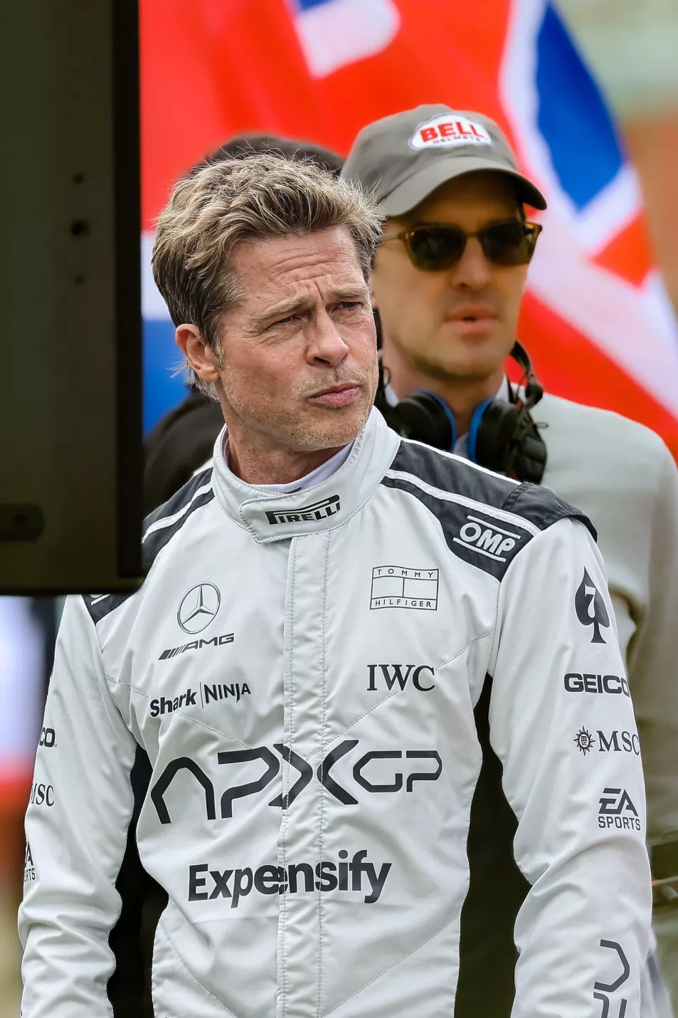 Брэд Питт позирует на съемочной площадке в черно-белом гоночном костюме во время съемок своего нового фильма «Формула-1».