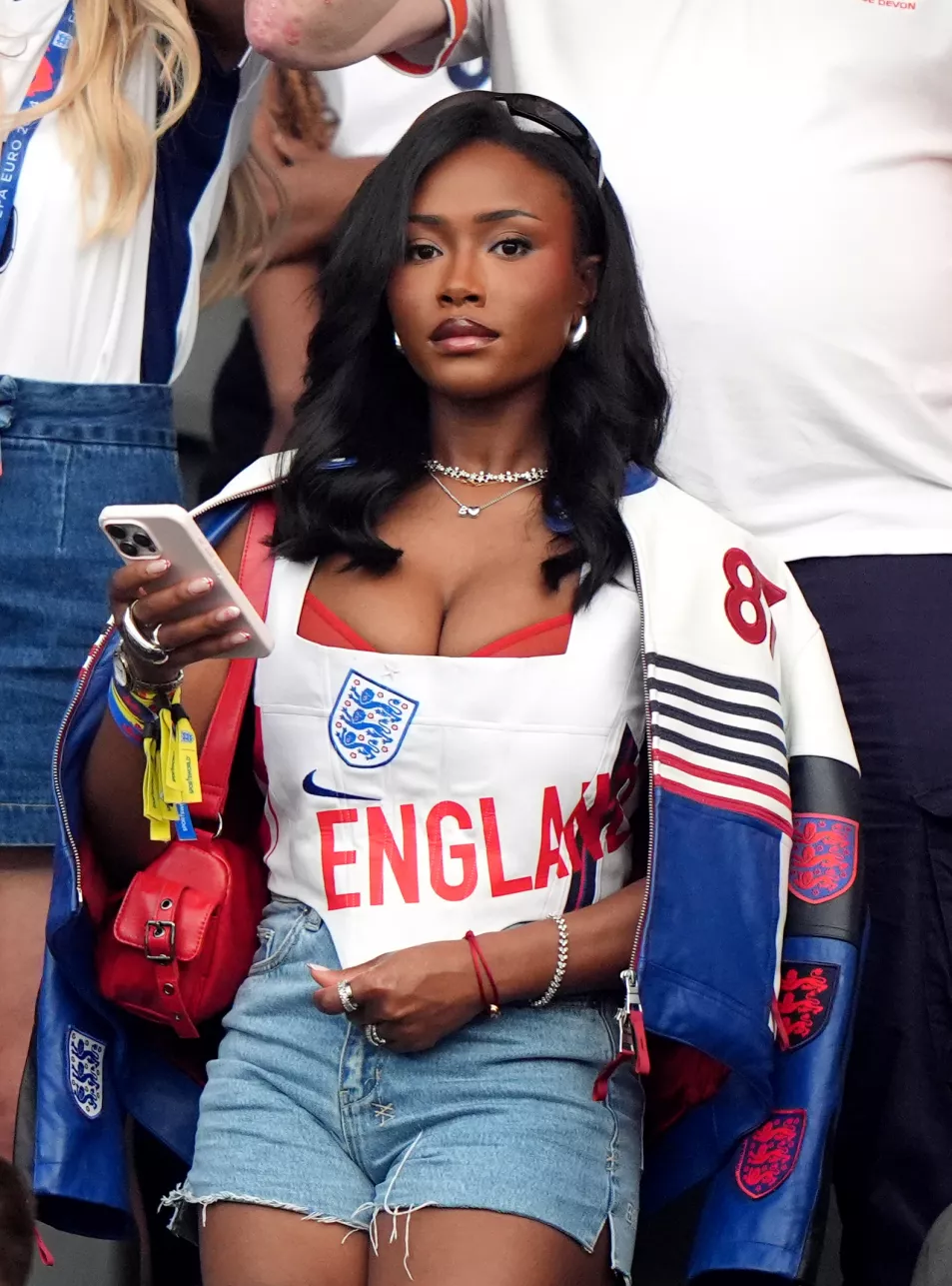 Tolami Benson watches from the stands in reworked England corset and sheer red bralette